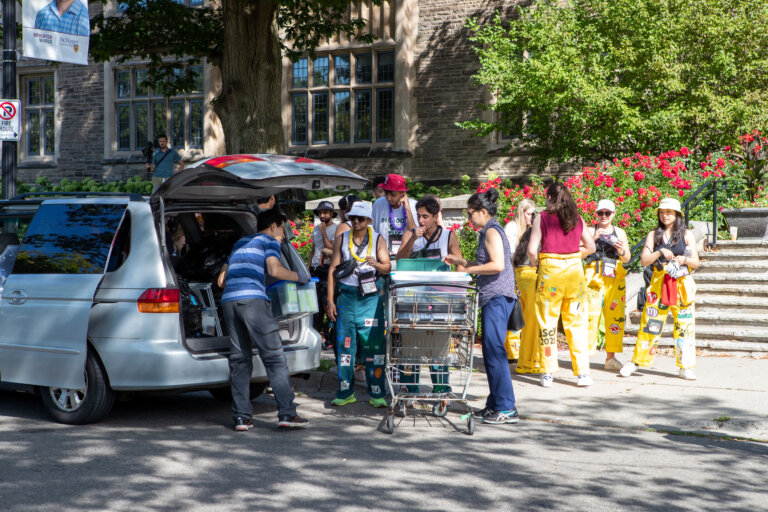 Welcome Week Move-In. Reps using shopping cart to transport student belongings to residence building.